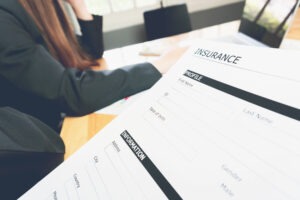 woman in suit in office showing an insurance policy, Concept fill their laptop to get online.